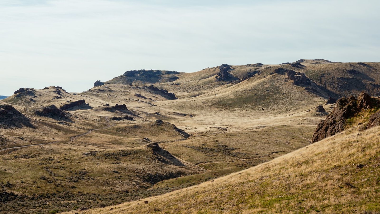 Open arid mountain valley with rugged ridges and backcountry roads.